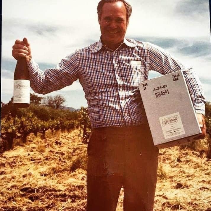 Jay Corley, Founder holding up a bottle of wine